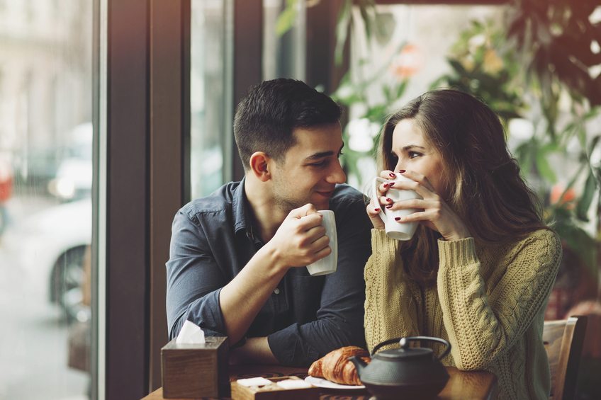 couple complice, se regardant en buvant une tasse de café
